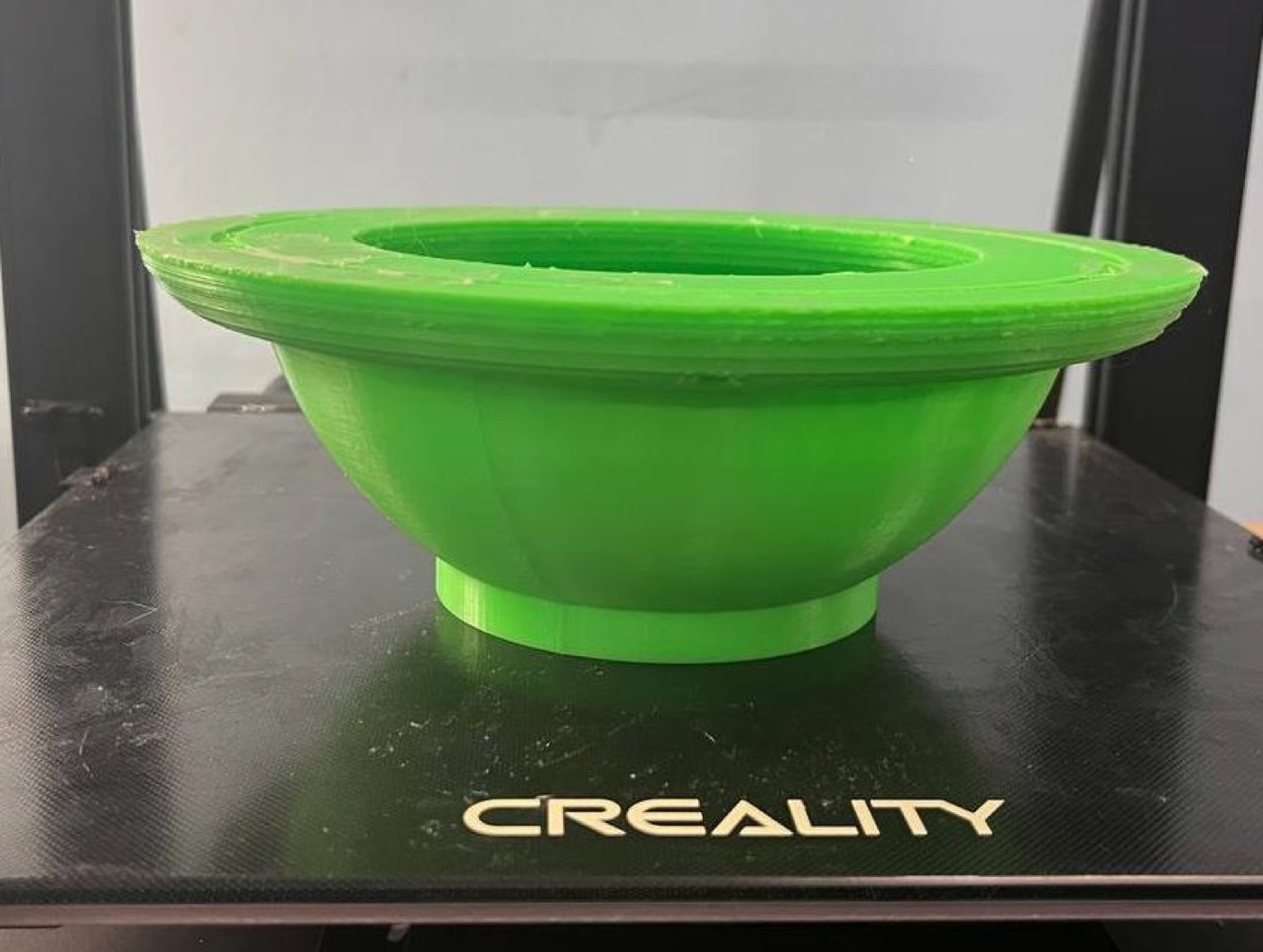 Casco de boya impreso en 3D, de color verde, recién salido de la impresora.