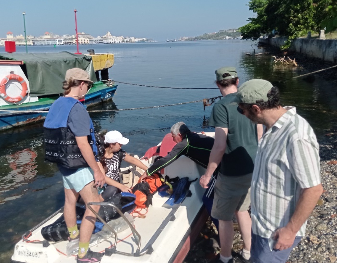 Equipo del proyecto a bordo de una embarcación, preparándose para abordar una boya en la bahía de La Habana.