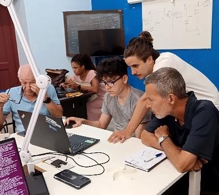 Micro-workshop: a group works around a computer while the devices are being built.