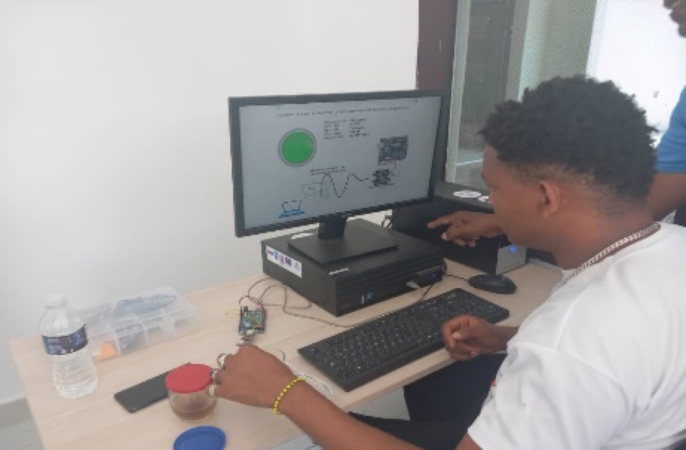 Estudiante frente a un monitor con una demostración de medición de calidad de agua potable.
